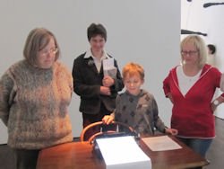 Foto:Mitglieder und G&auml;ste des Ortsvereins beim Betrachten eines Kunstwerkes, das mit Hilfe einer traditionelle Schreibmaschine hergestellt wurde